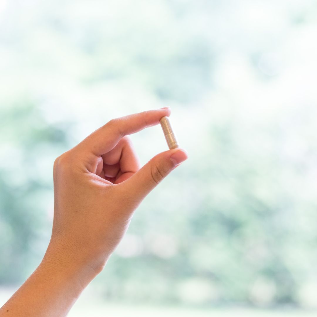 Person holding up a pill